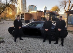 three-security-officers-standing-outside-black-car